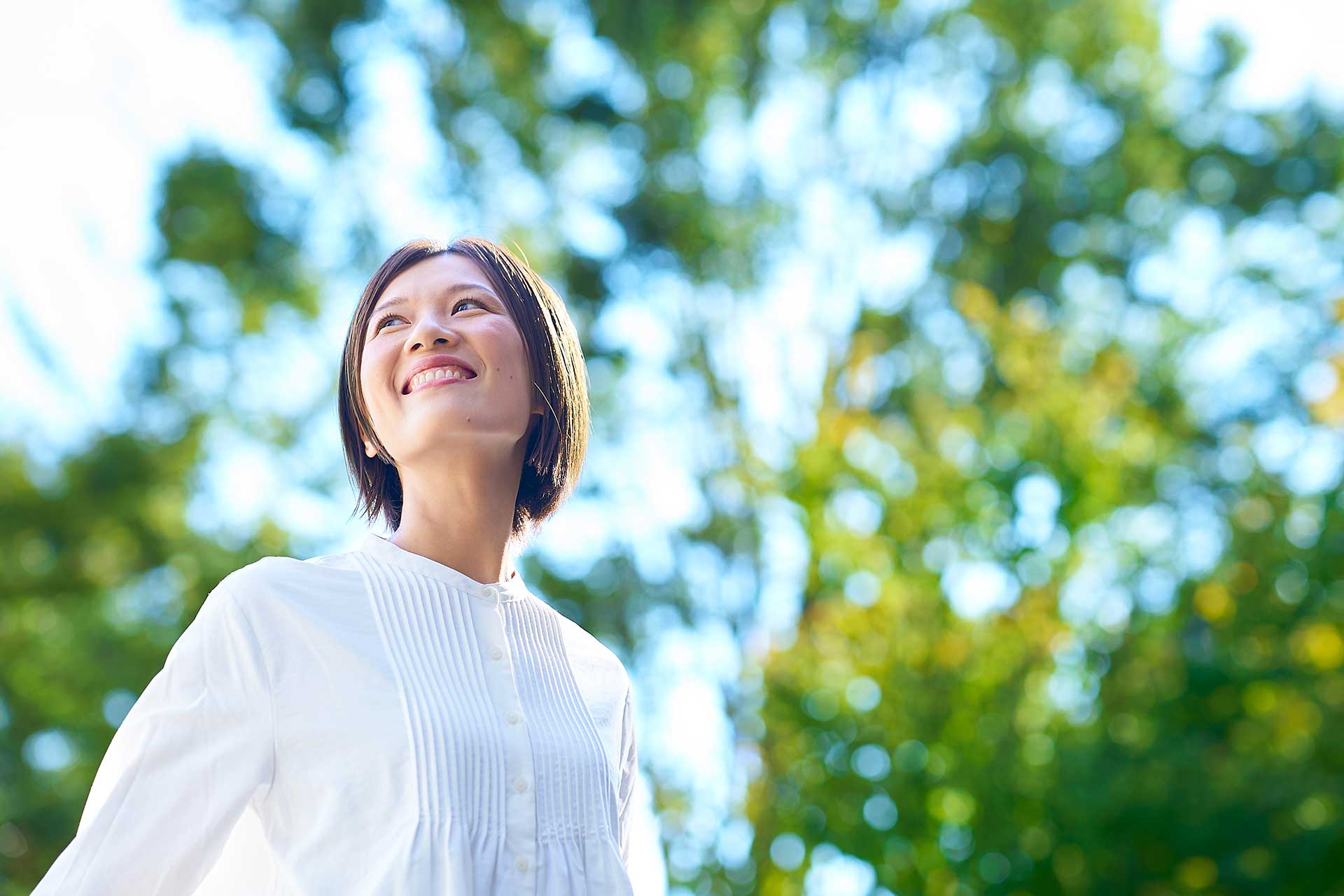 晴れた日に森の中で振り向く健康そうな女性
